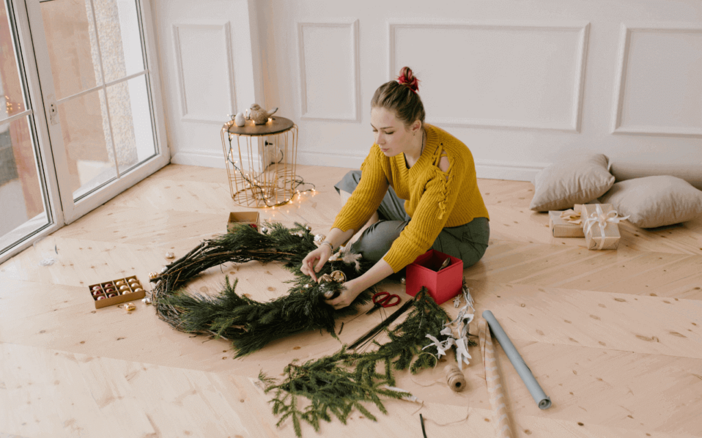 A woman creating a DIY green wreath