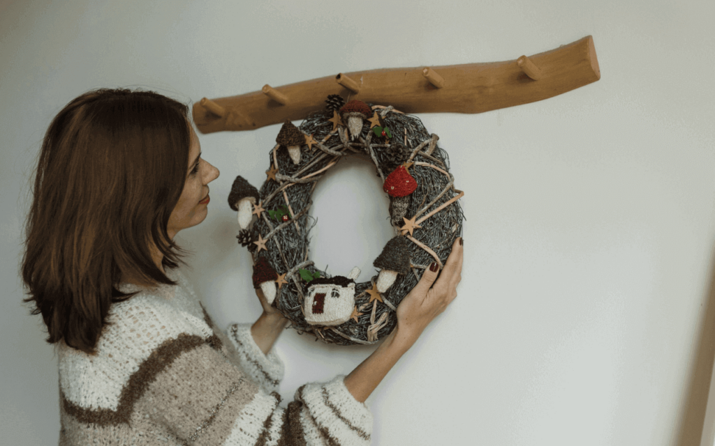 A woman hanging a wreath on the wall