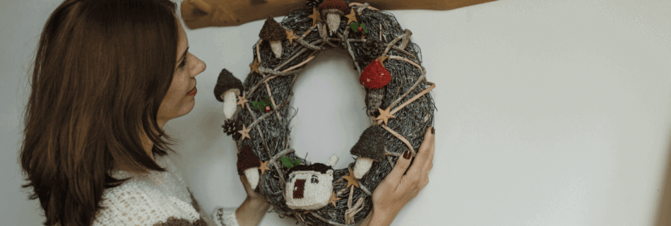 A woman hanging a wreath on the wall
