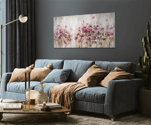 A living room with a gray sofa and brown pillows and a floral handpainted painting