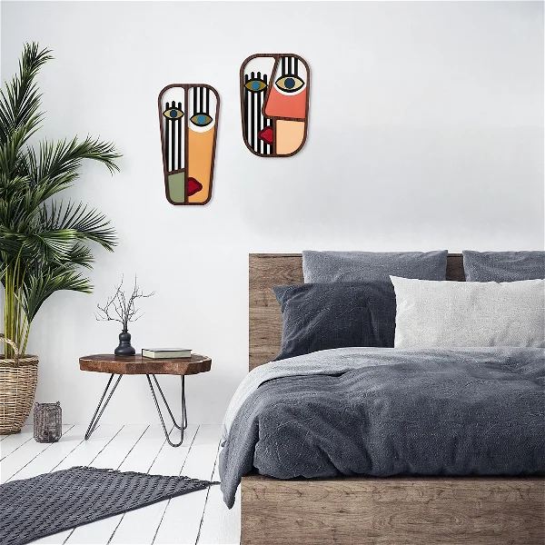 A wooden wall decoration hanged in the living room in colors of black orange ad brown with an image of a mask.