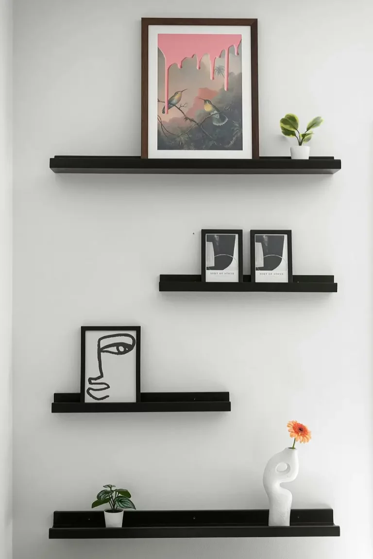 Floating shelf with framed pictures on the wall as creative ideas for hanging pictures