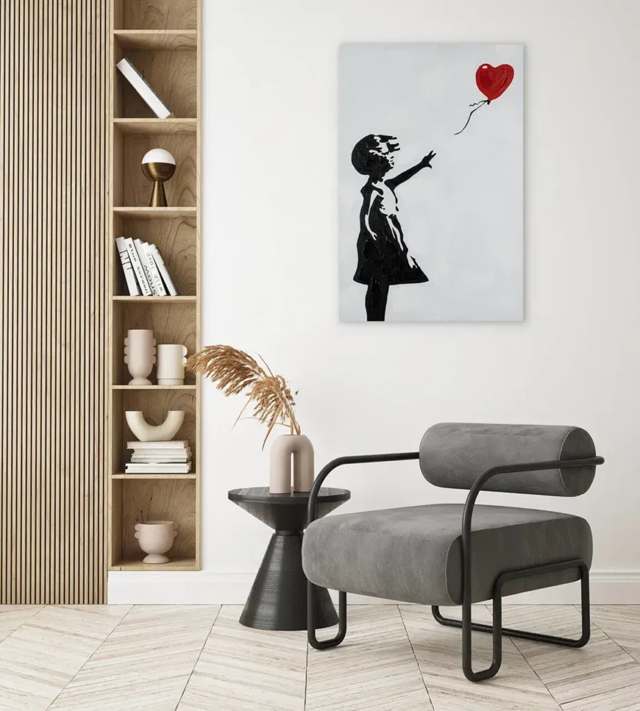 A living room corner with a painting of a girl holding a red balloon against a white background, hung on the wall.