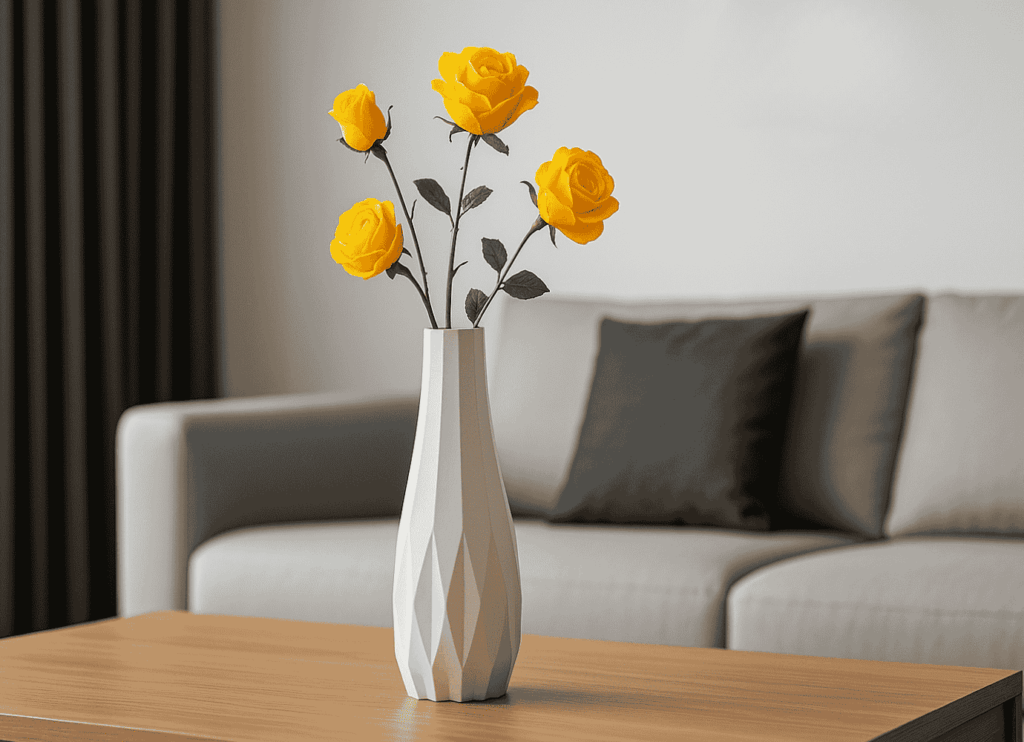 White geometric vase with yellow roses on a wooden coffee table, placed in a modern living room with a grey sofa.