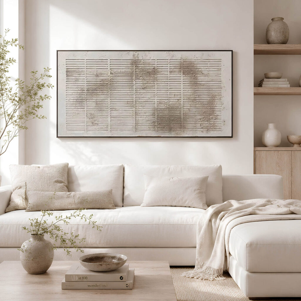 Bright neutral living room with horizontal textured abstract artwork above a white sofa.